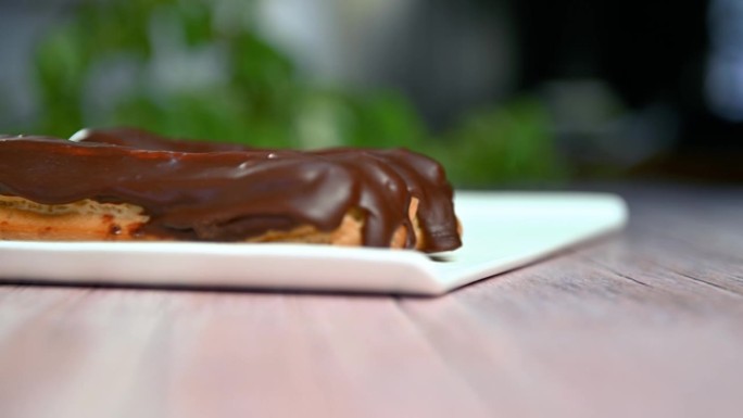 法式甜点泡芙配黑巧克力。女人把烤好的法式泡芙放在盘子里。