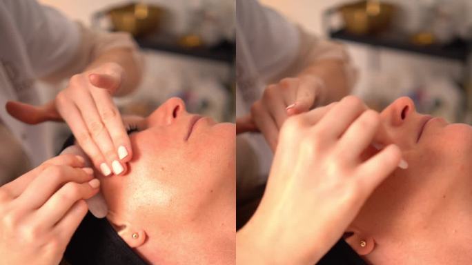美容师用瓜沙工具石给病人按摩脸部