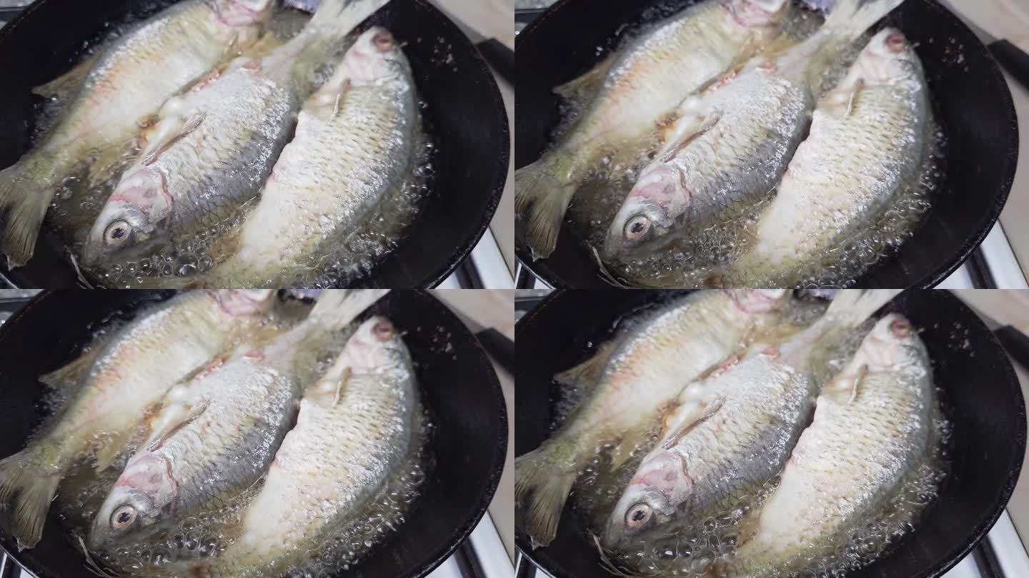 在家庭厨房用铁锅加油煎整条鱼