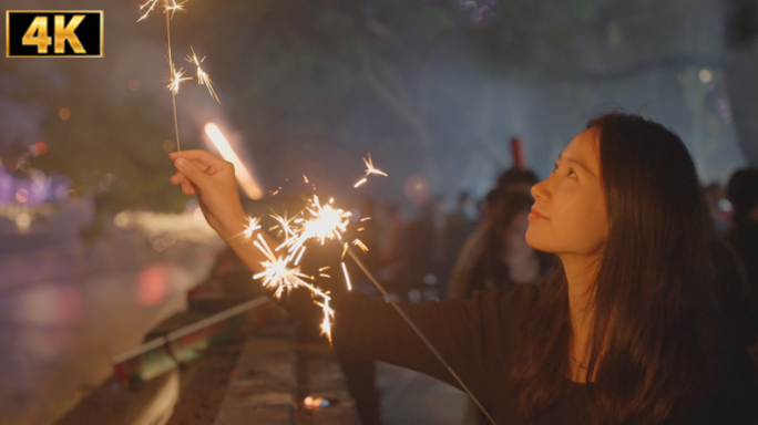 女孩放烟花 女子拿着火花庆祝新年 仙女棒