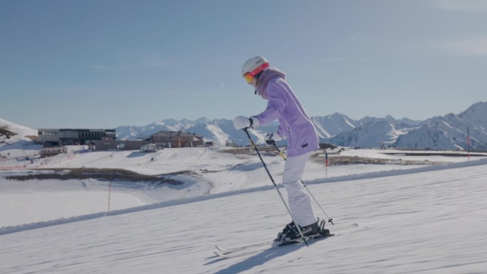 一个阳光明媚的冬日，一名年轻女子在阿尔卑斯山的滑雪胜地滑雪