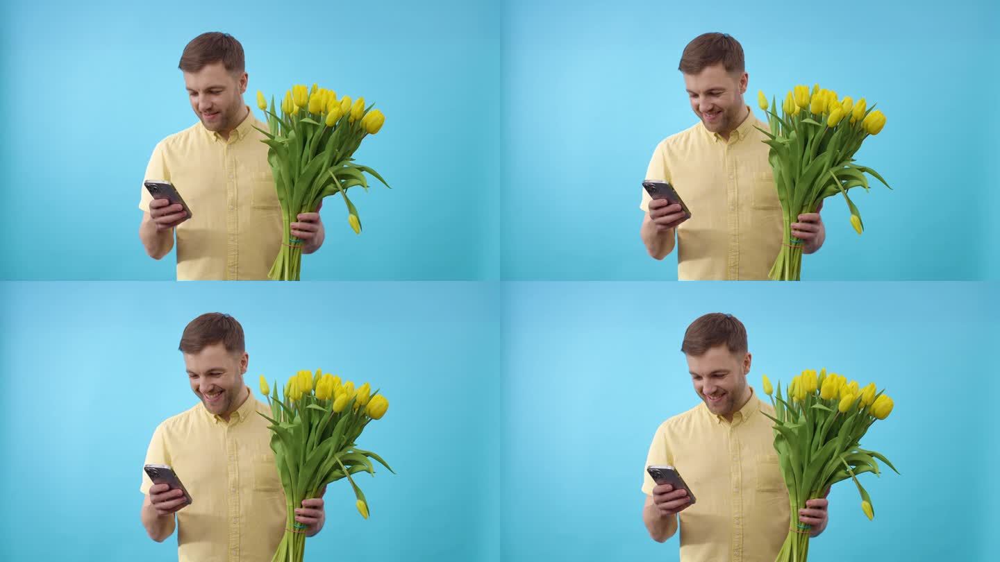一名男子拿着手机和一束蓝色背景的黄花