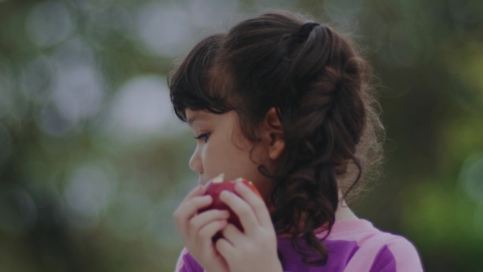 一个女孩在吃红苹果