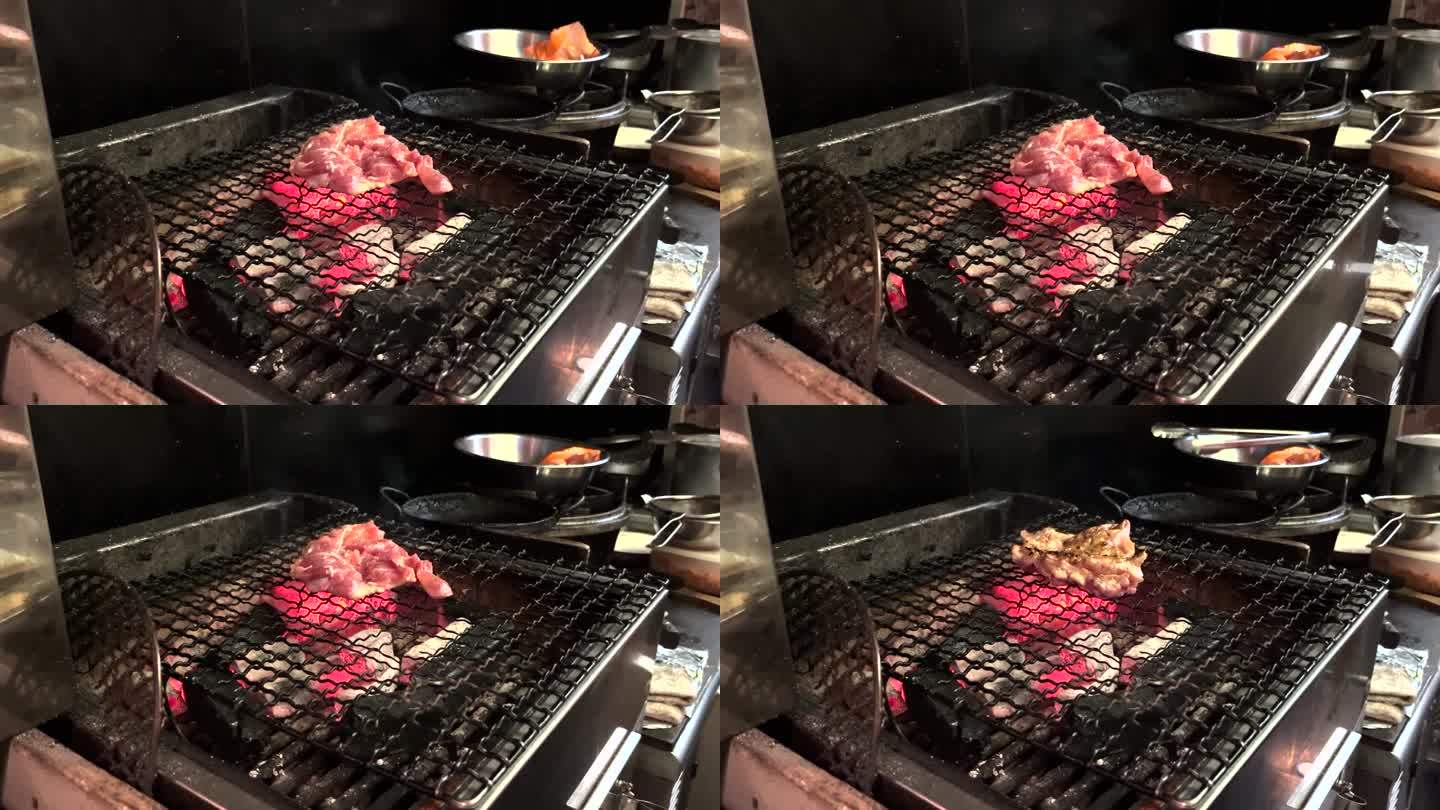 在日本一家餐馆的厨房里，一名厨师在木炭上烤鸡。