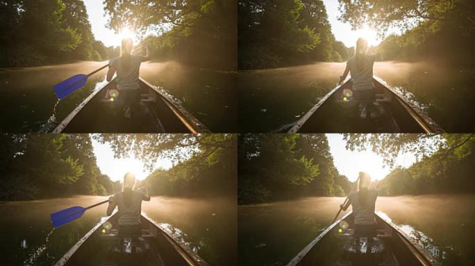 一个女人划着独木舟，在雄伟的雾蒙蒙的河流中探险
