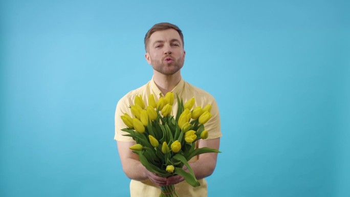 男子手持一束黄花，在蓝色背景上接吻