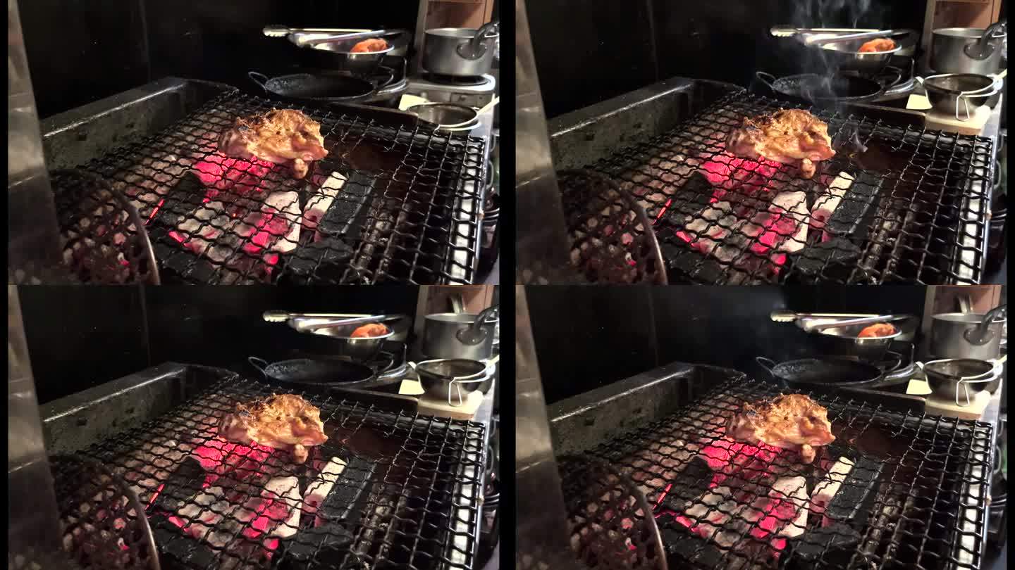 在日本一家餐馆的厨房里，一名厨师在木炭上烤鸡。