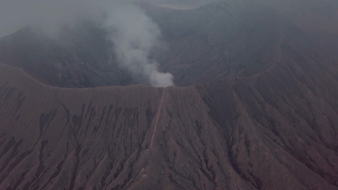 无人机鸟瞰图:布罗莫火山火山口边缘与蒸汽，亚洲。旅游目的地探险自然的概念