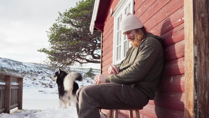 在挪威特隆德拉格郡的贝萨克，一名男子在冬天和他的狗一起品尝热饮——特写