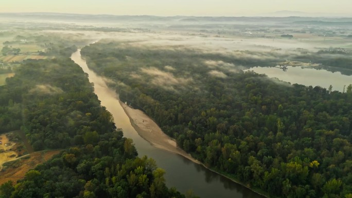 柔和的雾笼罩着穆尔河，蜿蜒穿过茂密的绿色森林