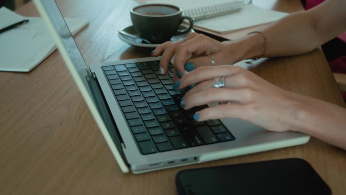 商务女性在笔记本电脑上打字的女性之手