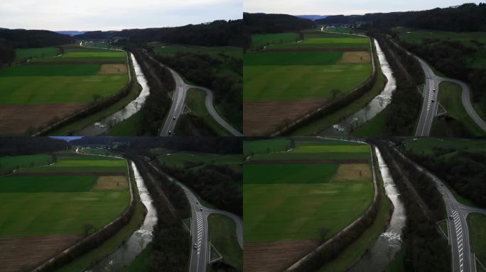 在青山环绕的德国高速公路上与行驶的汽车一起飞行