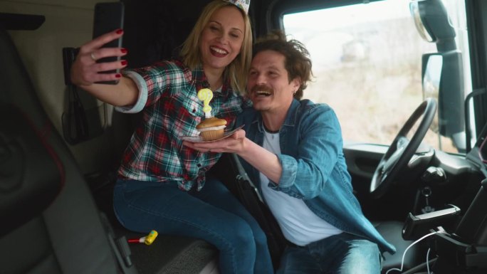 微笑的夫妇，家庭卡车司机庆祝生日在卡车驾驶室唱歌或视频通话