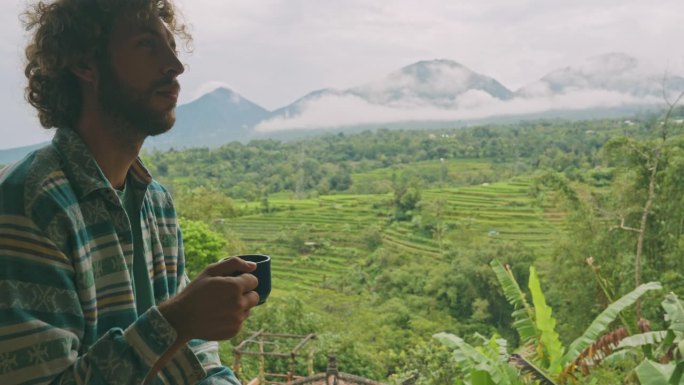 一个人在巴厘岛边喝咖啡边看稻田