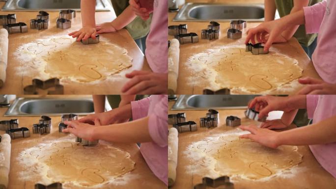 孩子们在厨房的台面上用木制擀面杖擀出饼干面团。金属烘烤模具。童年烘焙的乐趣，家庭传统，自制美食。兄弟