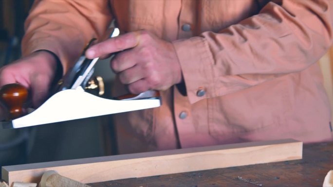 木匠用笨重的手刨刨木板。变形的效果。电影