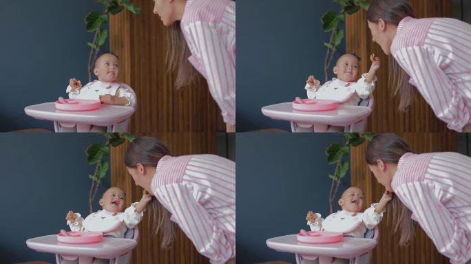 一个可爱的婴儿用手在嘴里喂妈妈。婴儿辅食