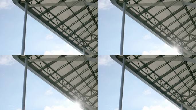在足球场的屋顶下，晴朗的天空，从下面拍摄的视角，日光。建筑。