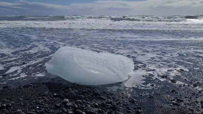 海浪前的黑海滩冰川，全球变暖和气候变化的概念