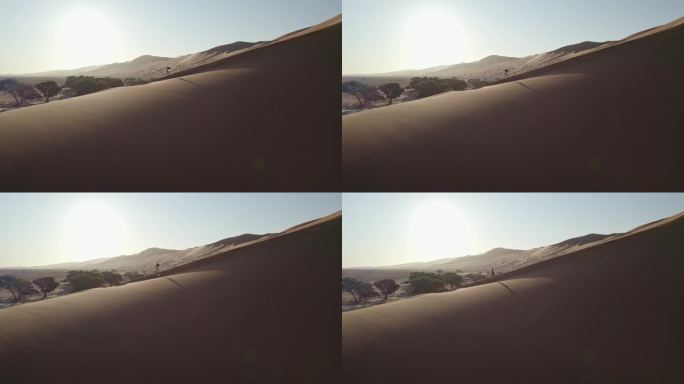 一个女孩走在沙漠里一个巨大的沙丘上