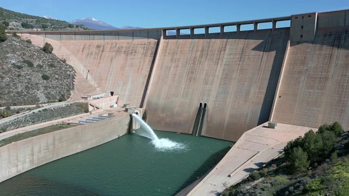 重力坝放水。豪厄尔饥饿阀工作。从空中俯瞰大坝和河流。可再生能源。水电站。到站