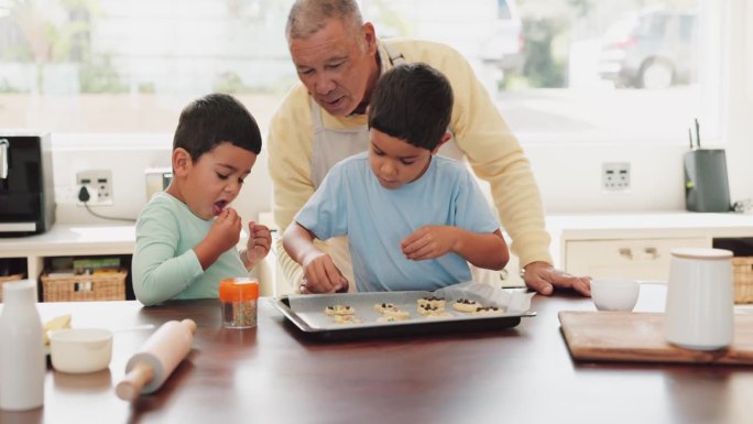 厨房，烘焙和男孩与他们的爷爷吃甜食，甜点或零食。亲密无间，原料和孩子们，饼干和饼干上撒点糖，和老人一