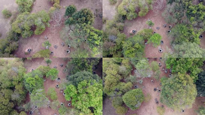 老挝丰萨旺的石缸平原。随机的罐子散落在绿色的森林区域。无人机鸟眼飞过。