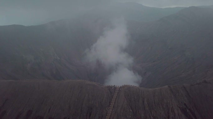 无人机鸟瞰图:布罗莫火山火山口边缘与蒸汽，亚洲。旅游目的地探险自然的概念