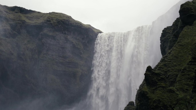 大瀑布的广角镜头，水从末日悬崖上倾泻而下。用辉煌的慢动作拍摄。Skogafoss冰岛。