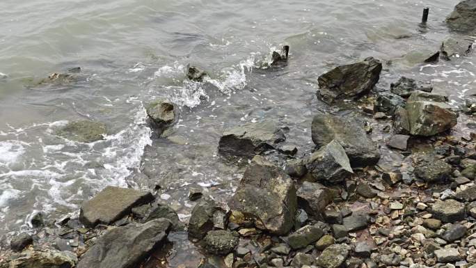 江水拍打岸边的岩石
