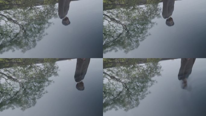 男子走路倒影在水面上
