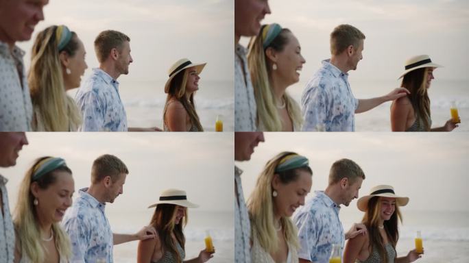 朋友团，男人和女人拿着一瓶康普茶饮料，走在海浪边谈笑风生的热带旅行。两对快乐的白人夫妇在海滨度假胜地
