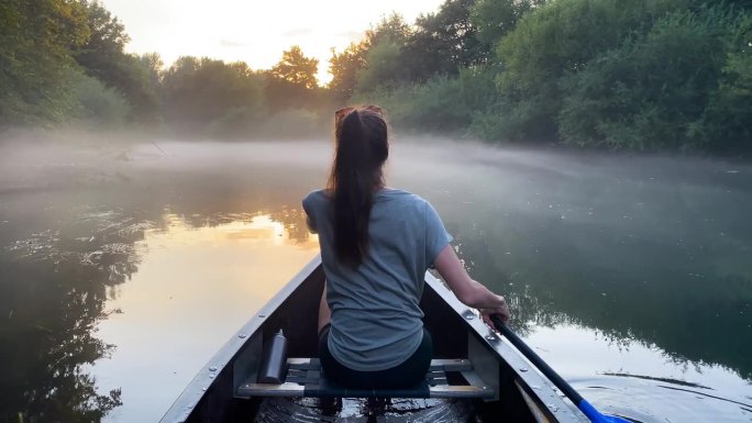 女子在独木舟探索令人惊叹的迷雾河