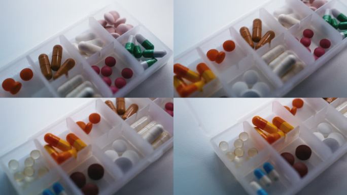 胶囊和药片的特写放置在每周的药物组织者，健康