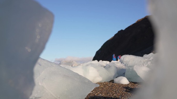 游客参观冰川区域位置，在阳光明媚的日子里在冰块之间行走
