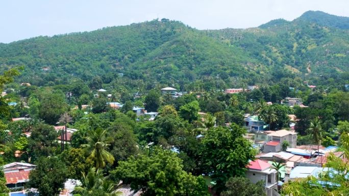 位于东南亚东帝汶首都帝力的当地社区住宅坐落在绿树和山丘之间，风景优美