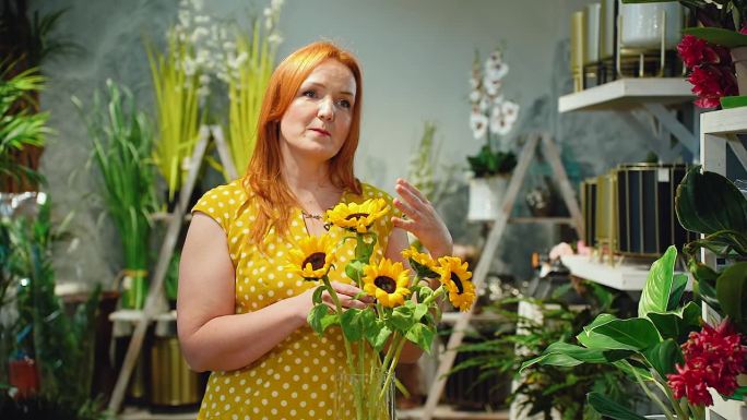 一位花店或温室里的博主花艺师，一位专业种花的成年女性，谈论装饰向日葵。在家里种植美丽明亮的花朵。