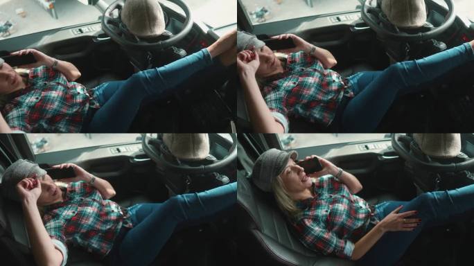 女司机一边打电话一边微笑，在空闲时间或休息时间放松地躺在卡车驾驶室里