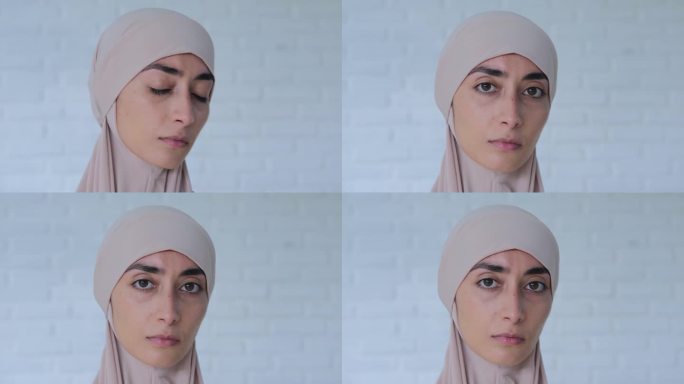 戴头巾的穆斯林妇女悲伤地看着镜头。优美的五官，坚定的目光，严肃的神情，传达着人的紧张状态。表情比语言