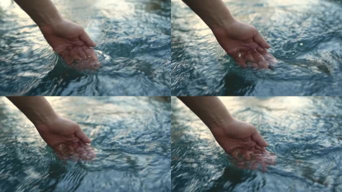 一只女性的手抚摸着河水