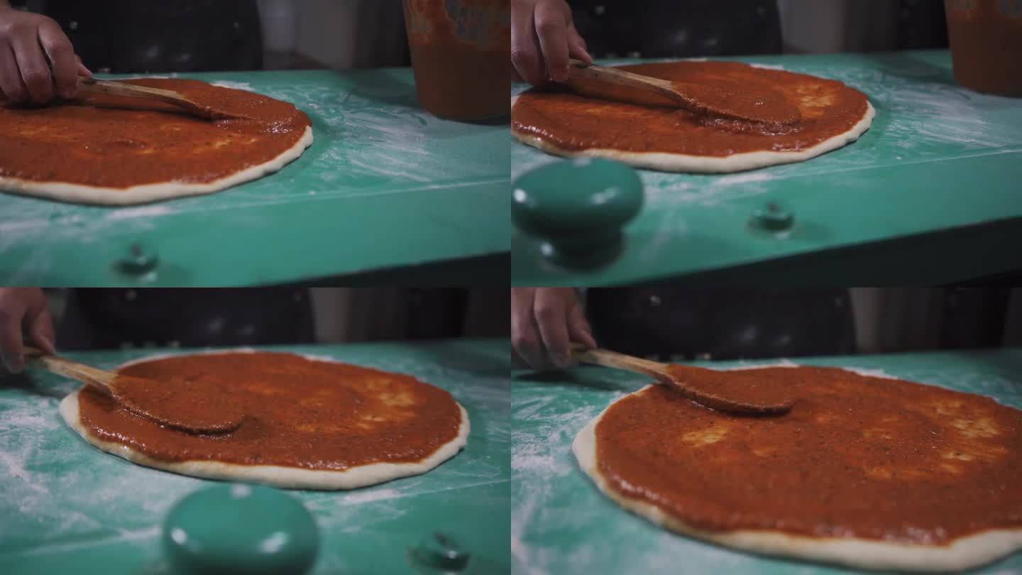 完美烹饪将红酱涂在披萨面团上