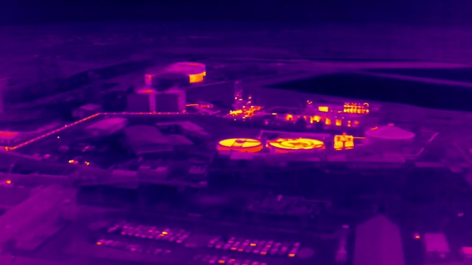 带有工厂和仓库的工业区的航空红外热视图，紫色和黄色色调