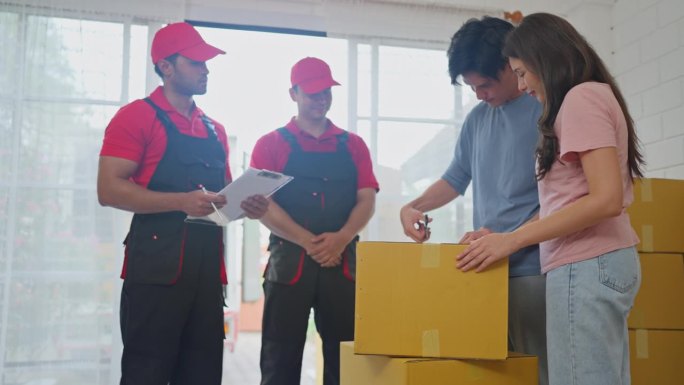 亚洲男人和女人检查盒子里的产品，快递员在把产品搬到新家的过程中为客户提供文件以供验证。