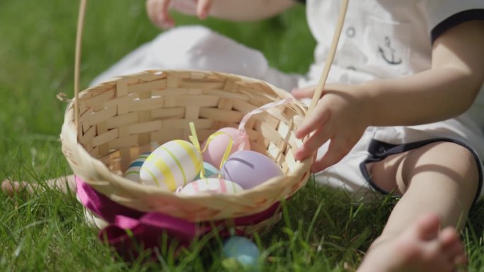 复活节快乐庆祝:特写镜头婴儿双手翻动篮子复活节彩蛋