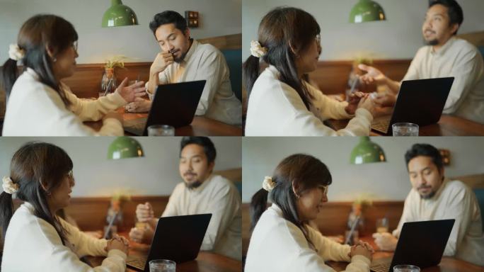 一群穿着便服的亚洲企业家在餐厅用电脑聊天。