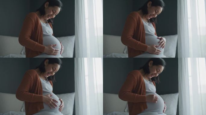 孕妇轻轻地抚摸她的肚子，怀孕/分娩