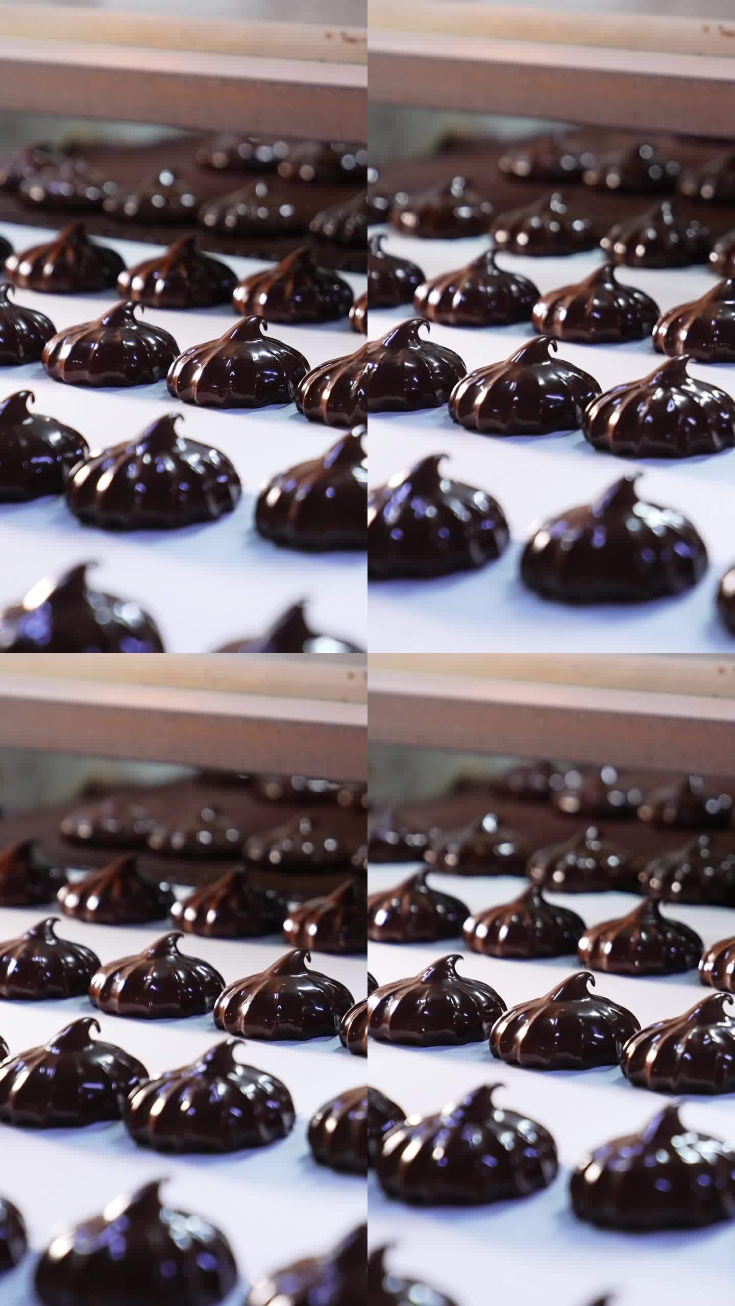 覆盖着巧克力的甜点从传送带移动到传送带。新鲜制作的西风甜品特写。垂直视频