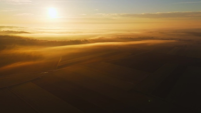 日出时被雾笼罩的农村农业景观鸟瞰图