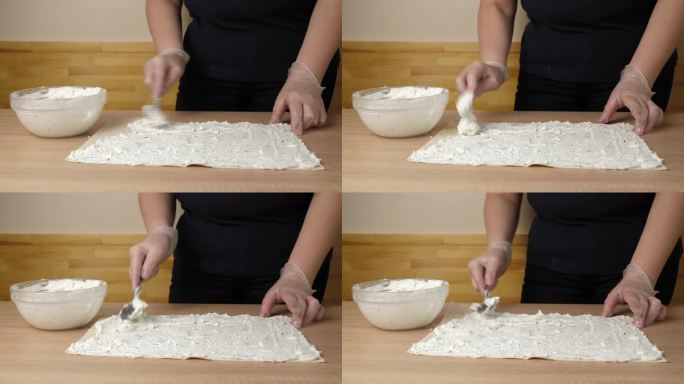 在展开的皮塔饼上放上一层奶酪馅。皮塔饼卷的制作。