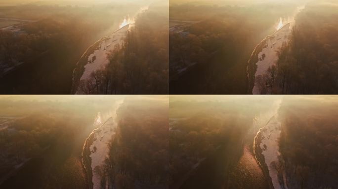 黎明时分，穆尔河在冬日树木间流动的航拍照片